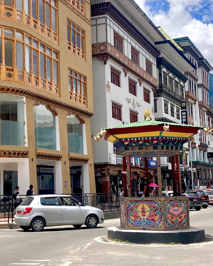 about-us Colorful traditional architecture and vibrant traffic scene in Thimphu, Bhutan.